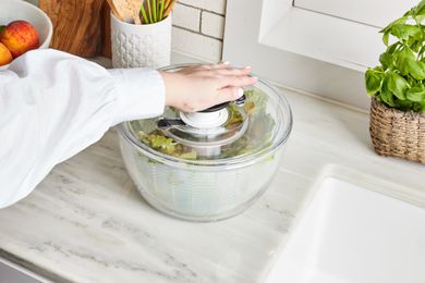 hand pumping OXO salad spinner