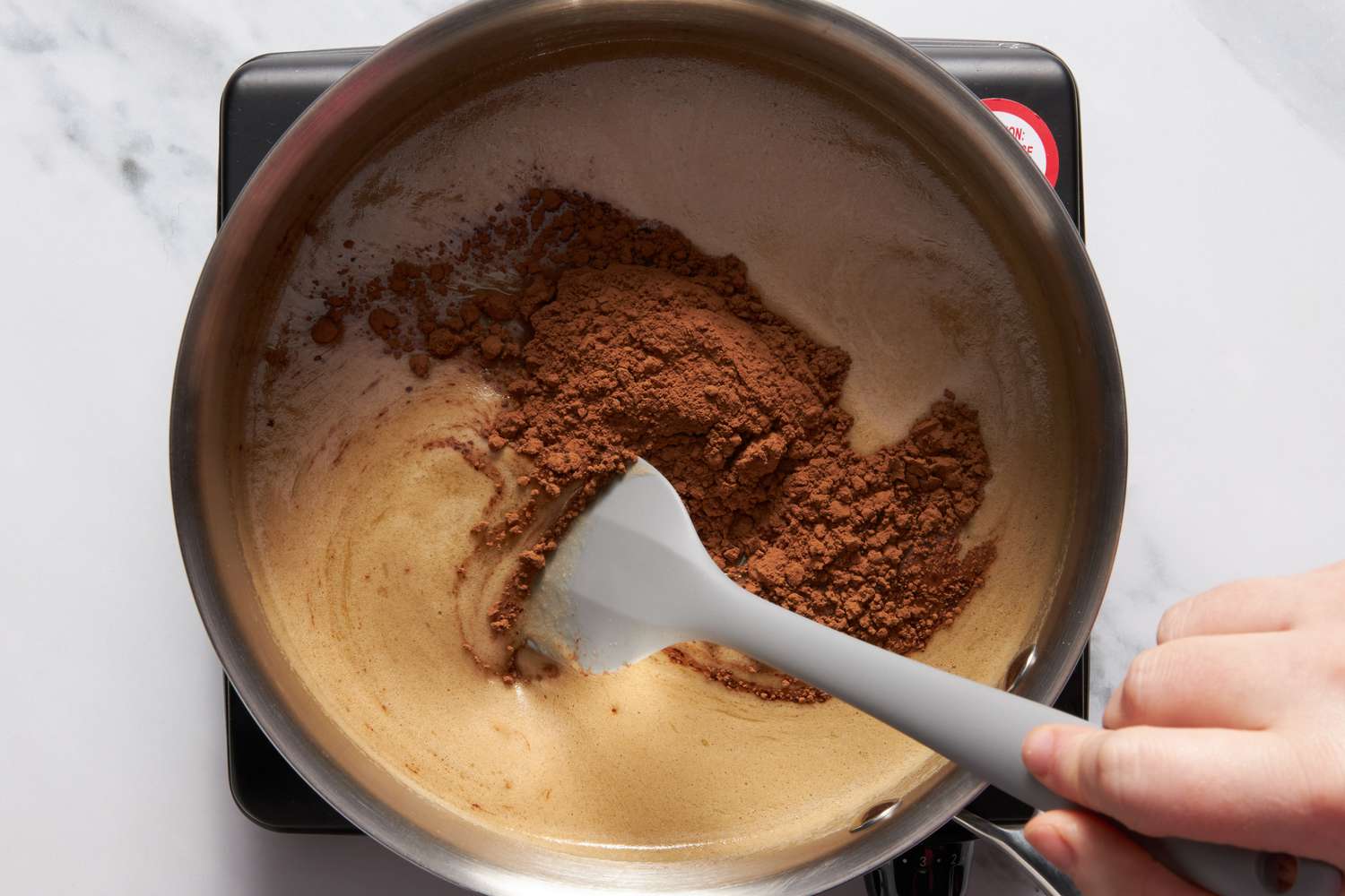 Butter, sugar, cocoa, and Dr. Pepper in a sauce pan, boiled over a portable stove for Dr. Pepper cake recipe