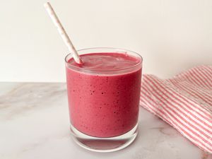 3-ingredient smoothie in a short glass with a white paper straw with light pink polka dots
