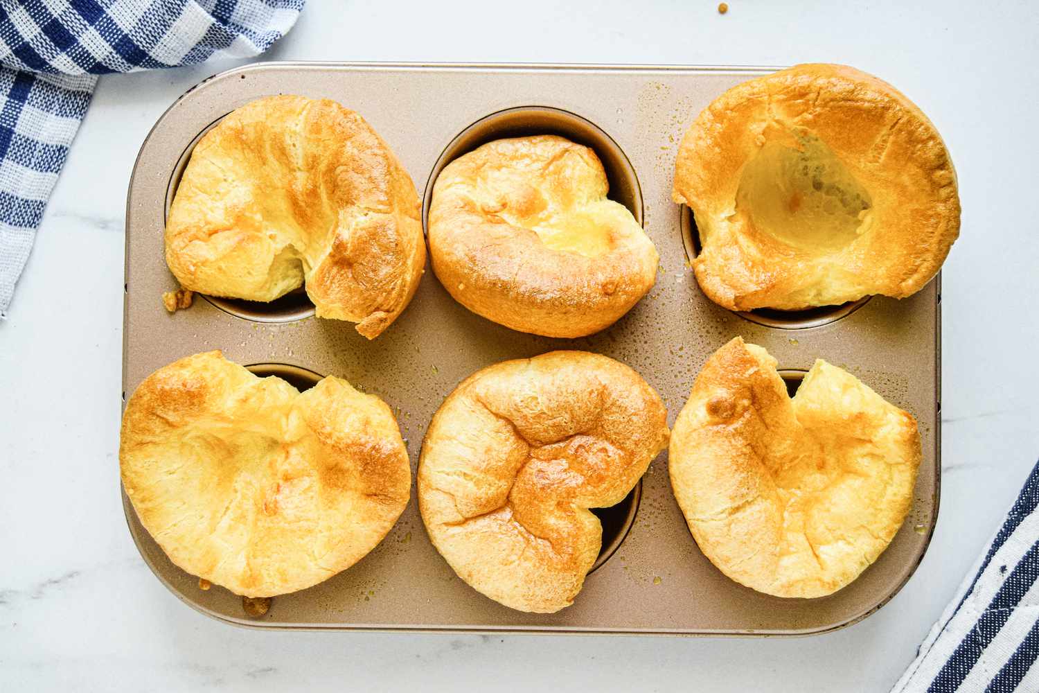 Overhead view of yorkshire puddings in a muffin tin.