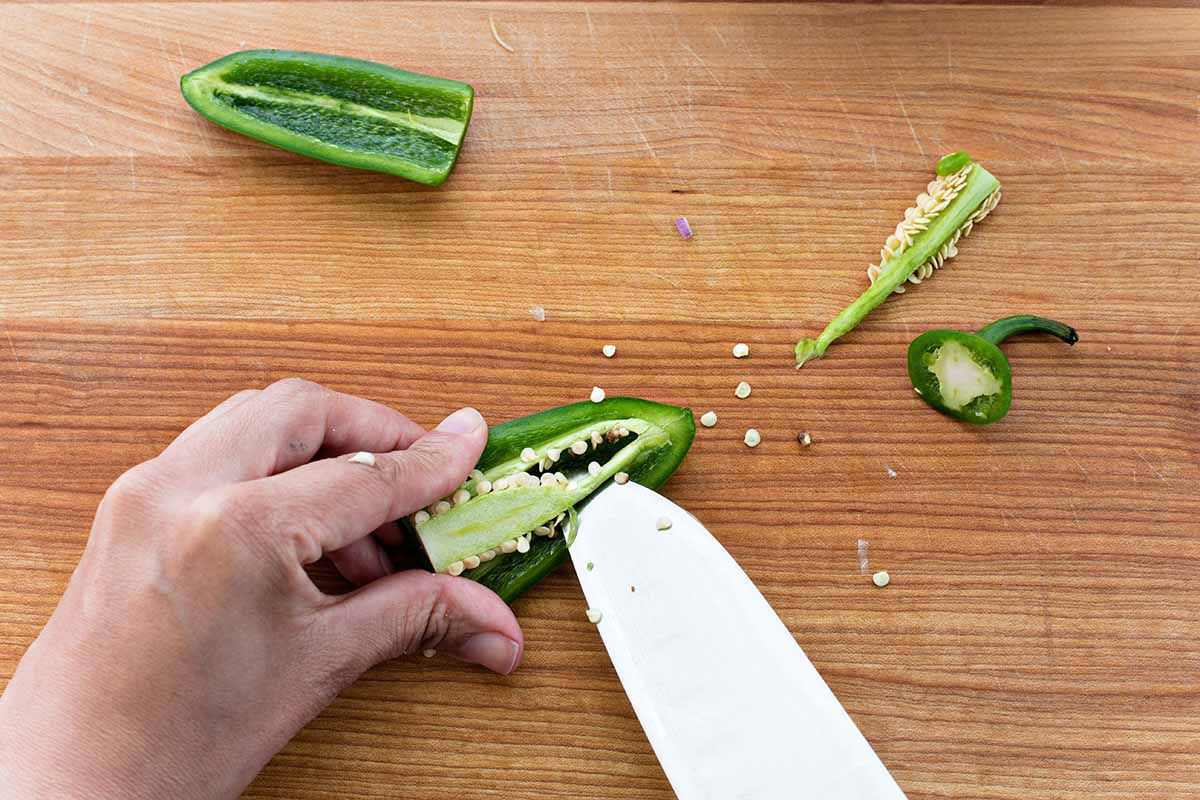 Chipotle Mexican Grill Guacamole - person seeding a jalapeno
