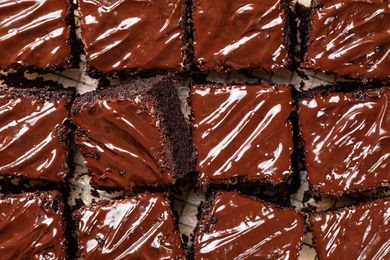 Slices of chocolate cake topped with shiny chocolate frosting