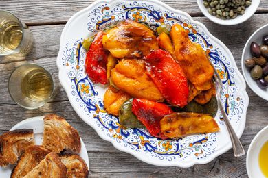 Platter of Grilled Peppers Surrounded by Olives, Capers, Olive Oil, and Toast
