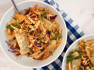 A bowl with the Trader Joe's Miso Crunch Chopped Salad Kit and dumplings