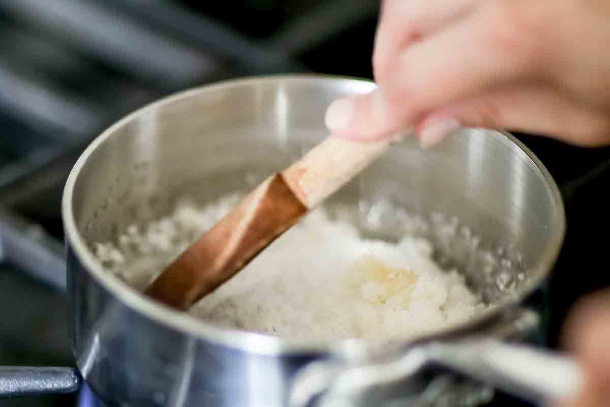 Sugar being stirred and melted in a pan