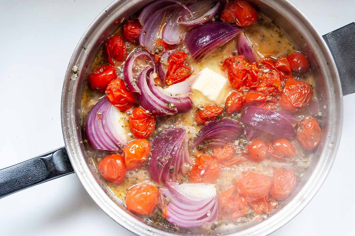 Easy Skillet Chicken-tomatoes, red onion, and butter cooking in a skillet