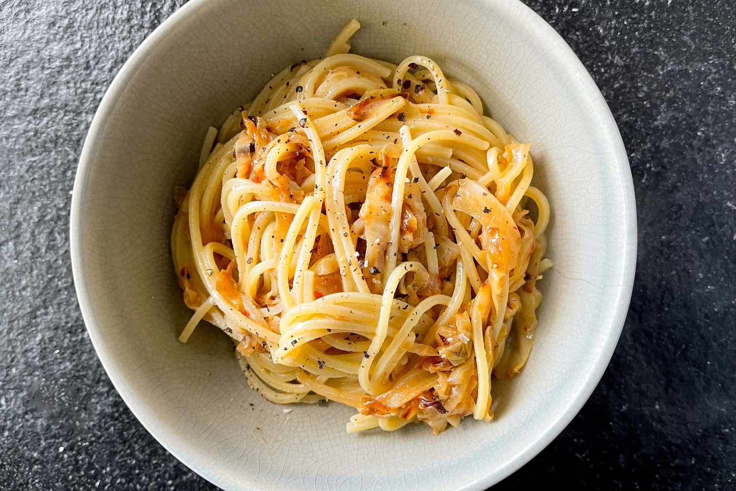 A white bowl with caramelized cabbage spaghetti recipe