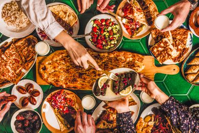 family enjoying middle eastern food (dolma, kebabs, flatbread) for iftart, Ramadan