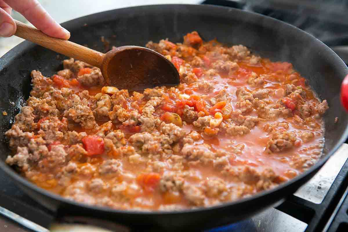 add tomatoes to white beans and sausage