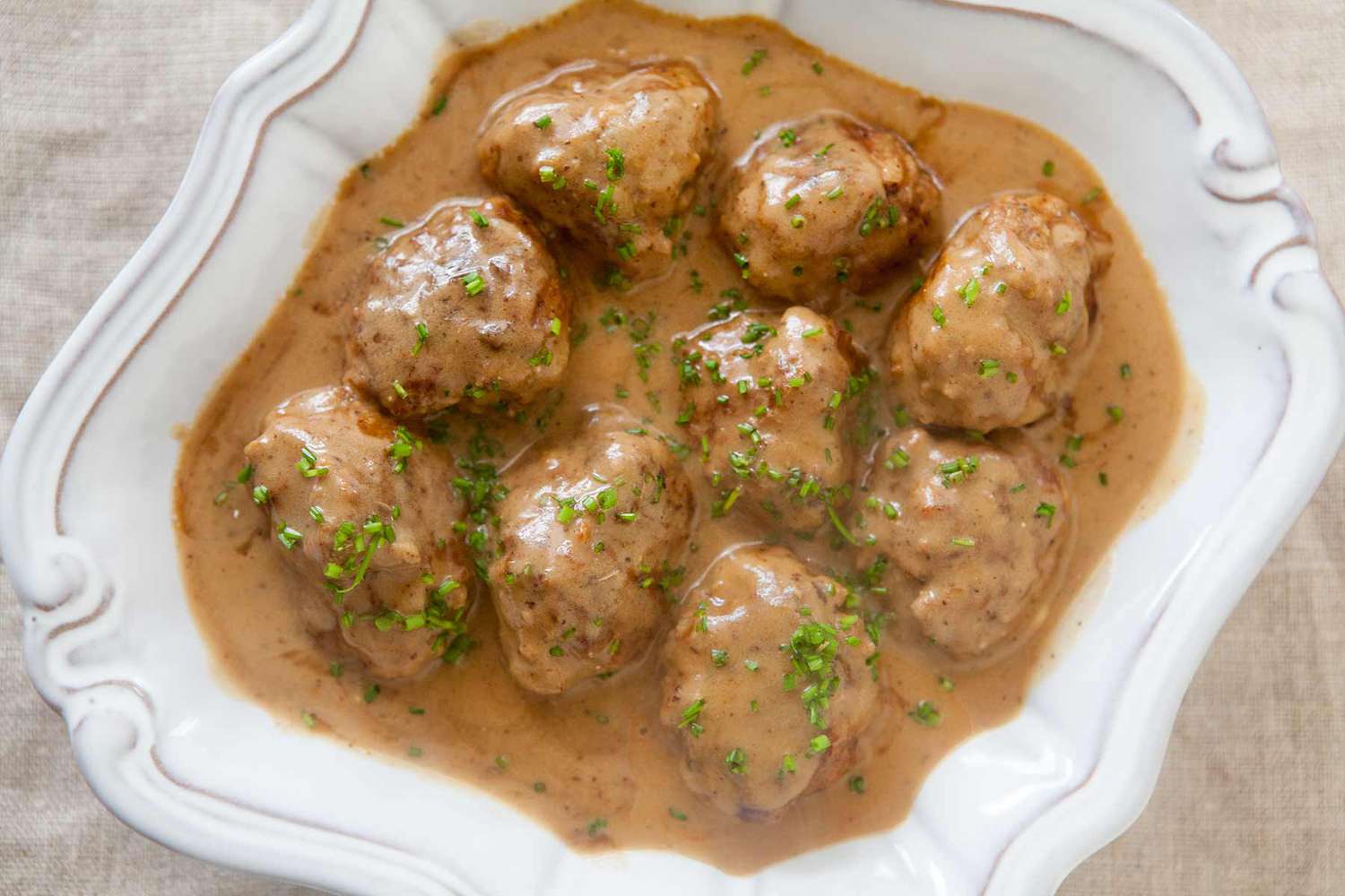 Swedish meatballs covered in sauce and resting on a serving platter