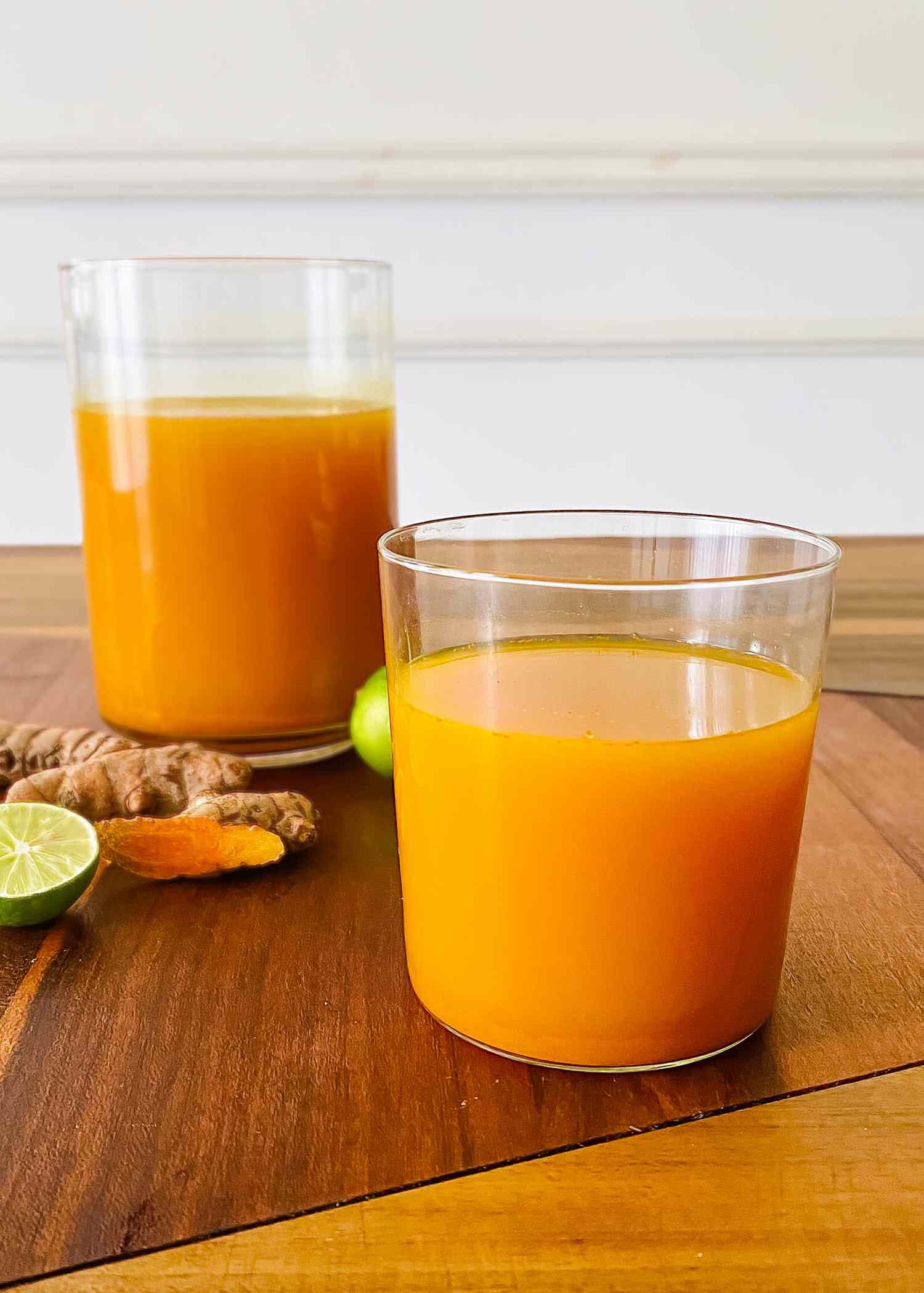 A glass and pitcher filled with Turmeric and Ginger Mocktail..