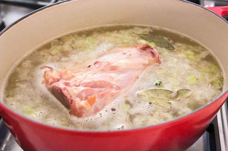 Large ham bone simmering in pot 