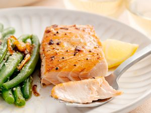 Plate of Salmon Filet with Brown Sugar Glaze and a Side of Green Beans. Some of Salmon Is on the Fork.
