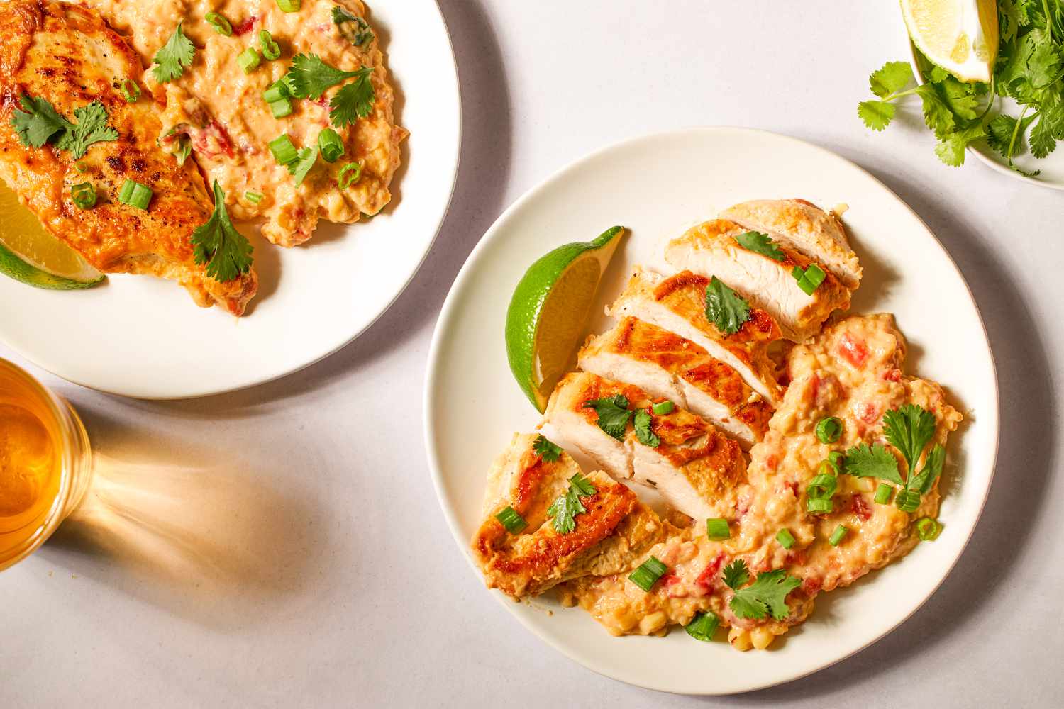 plate of Southwest Creamed Corn and Chicken, garnished with herbs, green onions, and lime slices