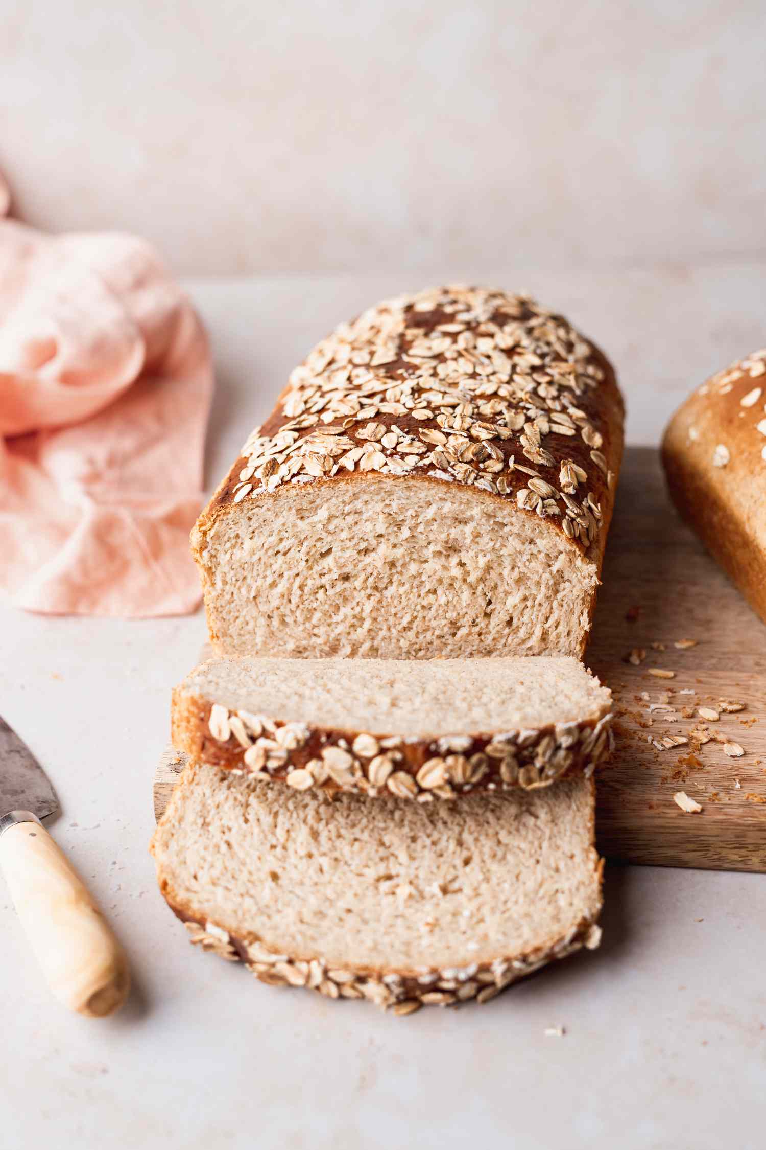 Front view of a loaf of a partially sliced loaf of oat bread 