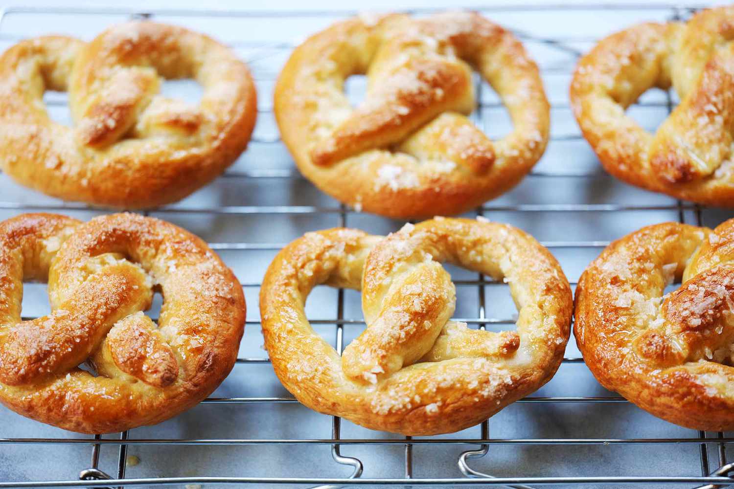 Six Philly soft pretzels cooling on a cooling rack