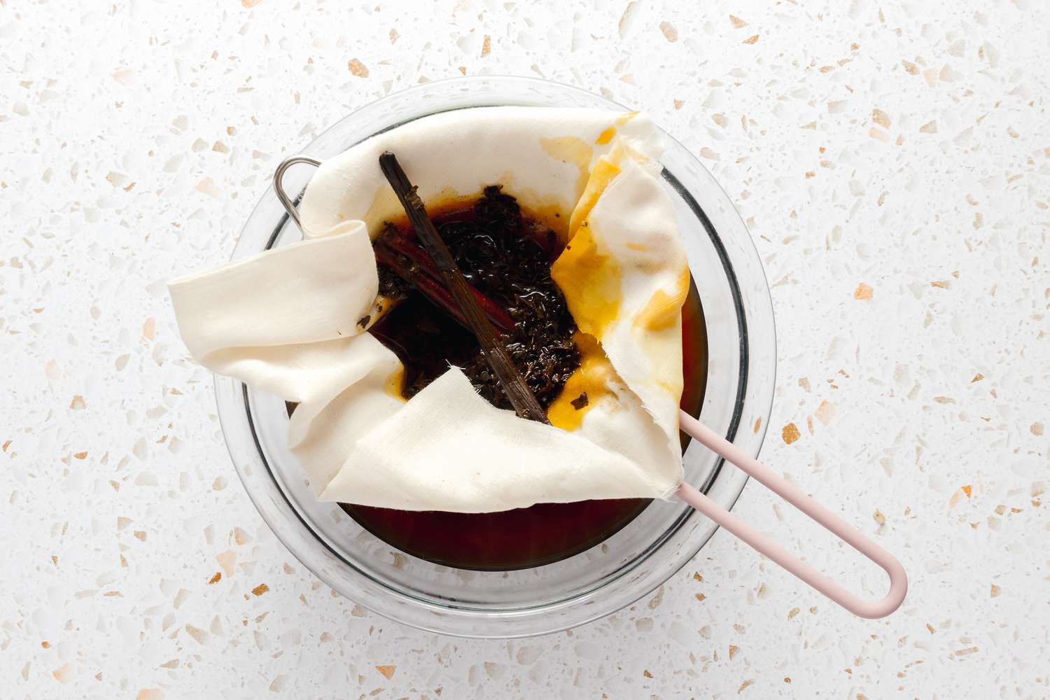 Thai Iced Tea Ingredients Strained Through a Cheese Cloth and Colander Into a Glass Bowl 