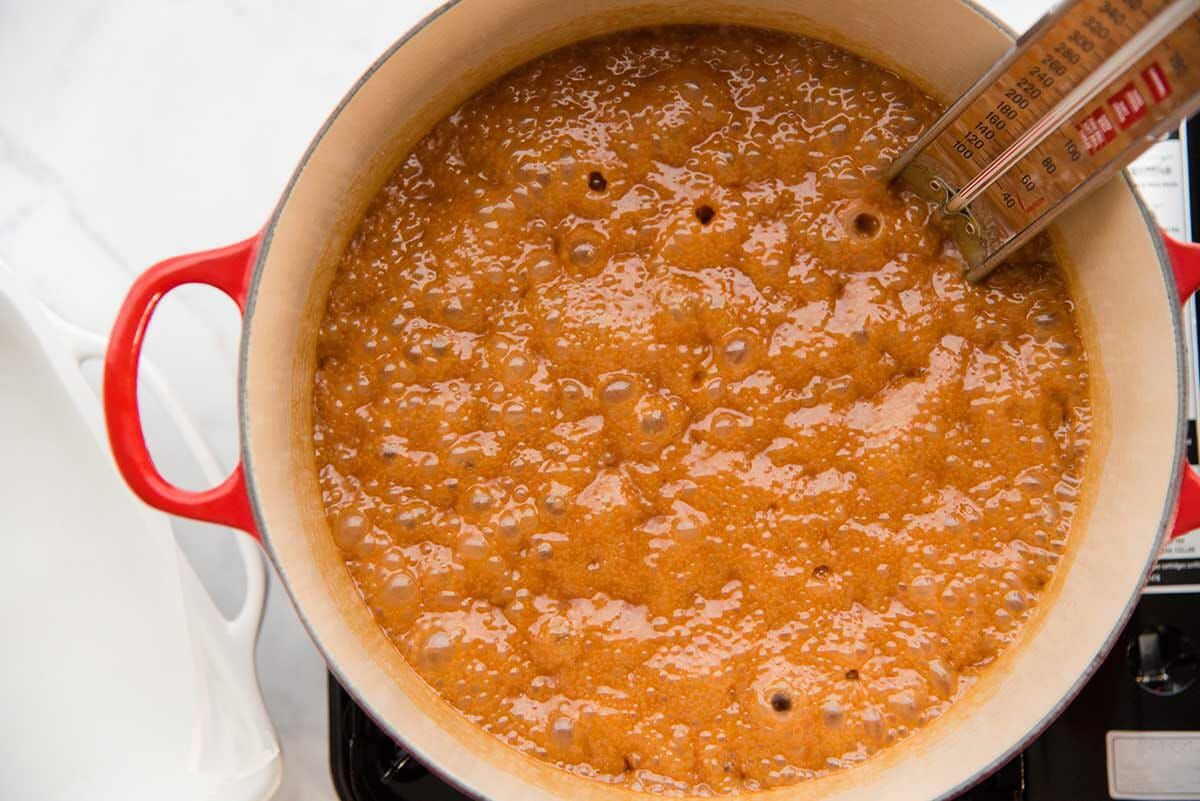 How to Make Caramel Candies by cooking the caramel until golden brown in a dutch oven with a candy thermometer in the pot.
