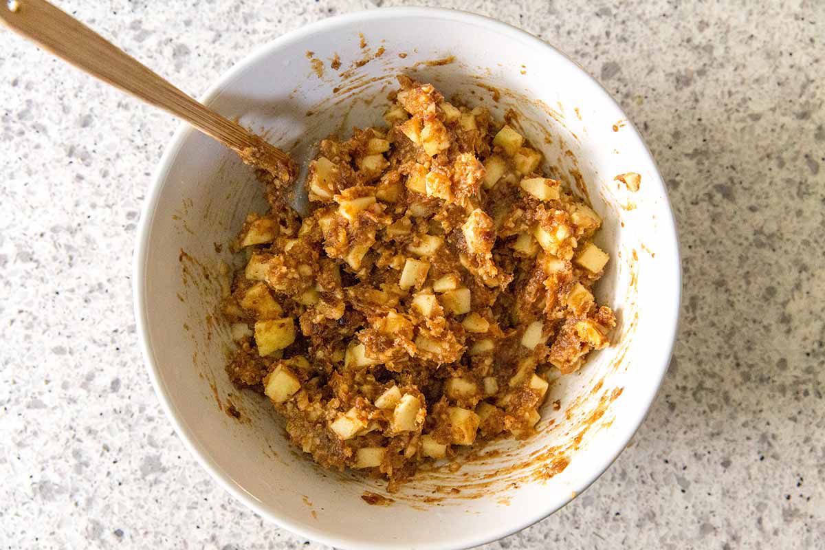 Charoset Recipe for Passover - apples, pureed walnuts, dates and spices being mixed together with a spoon.
