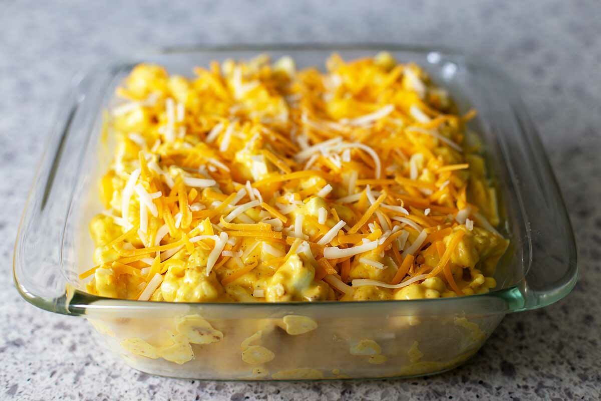 Shredded cheese tops a casserole dish with Baked Cheesy Cauliflower inside.