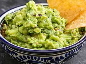 A bowl of guacamole with tortilla chips