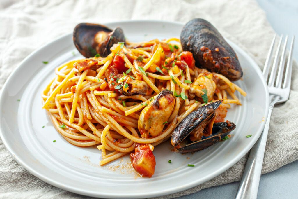 How to Cook Mussels in Tomato Sauce - spaghetti with sauce and mussels on plate