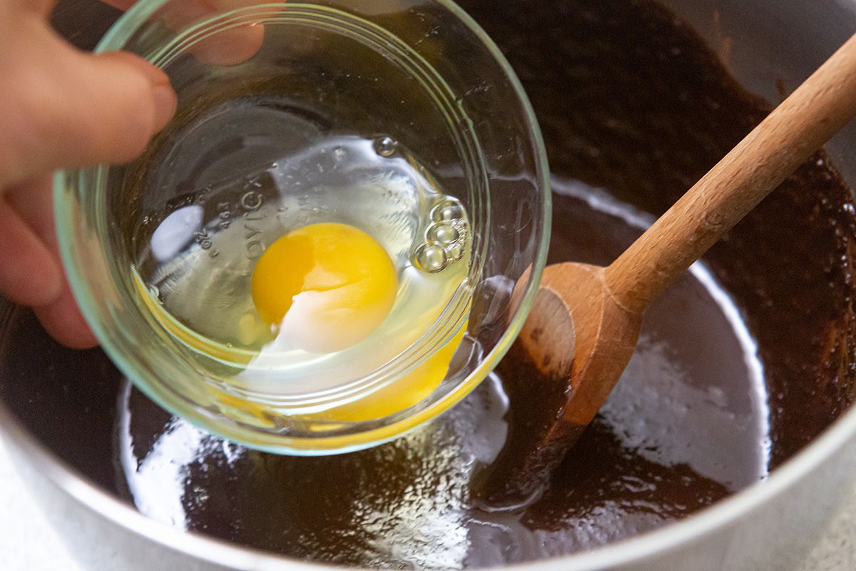 Eggs added to chocolate mixture to make brownies from scratch.
