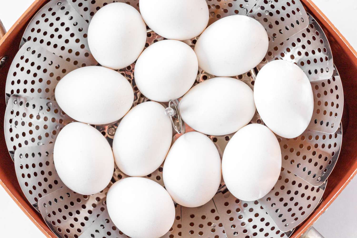 White eggs in a steamer basket to make Classic Deviled Eggs.