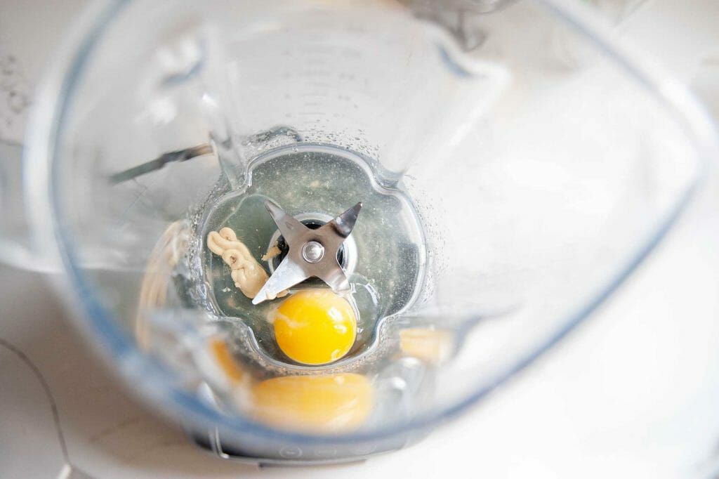 Egg yolk, oil, and mustard in the blender for homemade mayonnaise