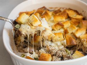 Spoon of Philly cheesesteak lifted from casserole.