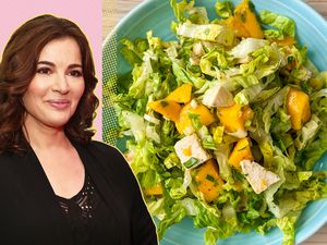 Nigella Lawson next to a plate of salad with greens, mango, and chicken