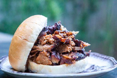bbq pulled pork shoulder on a burger bun sitting on a plate