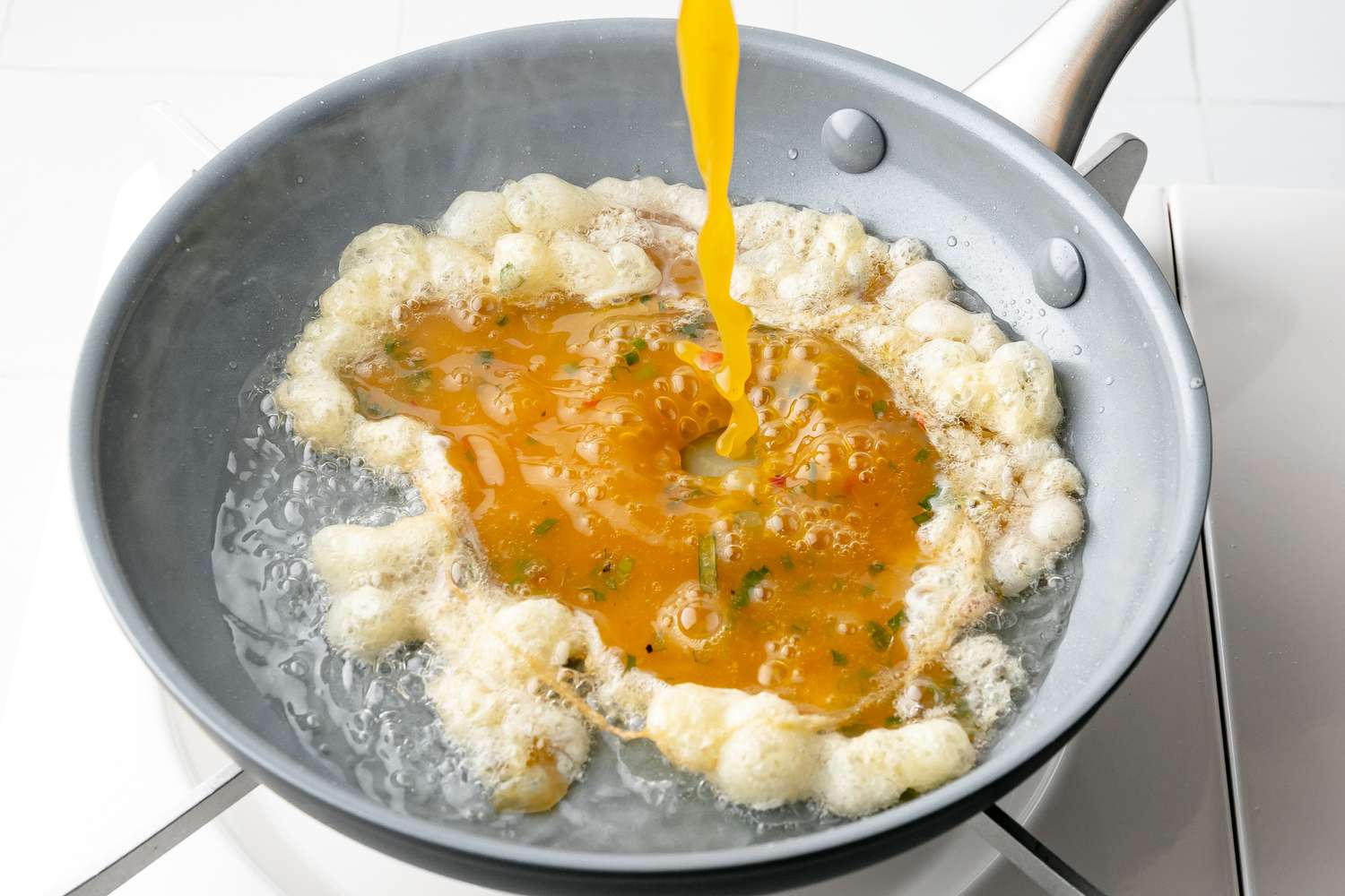 Thai Omelet Mixture Poured into Pan with Hot Oil, Causing Egg Mixture to Bubble and Sizzle