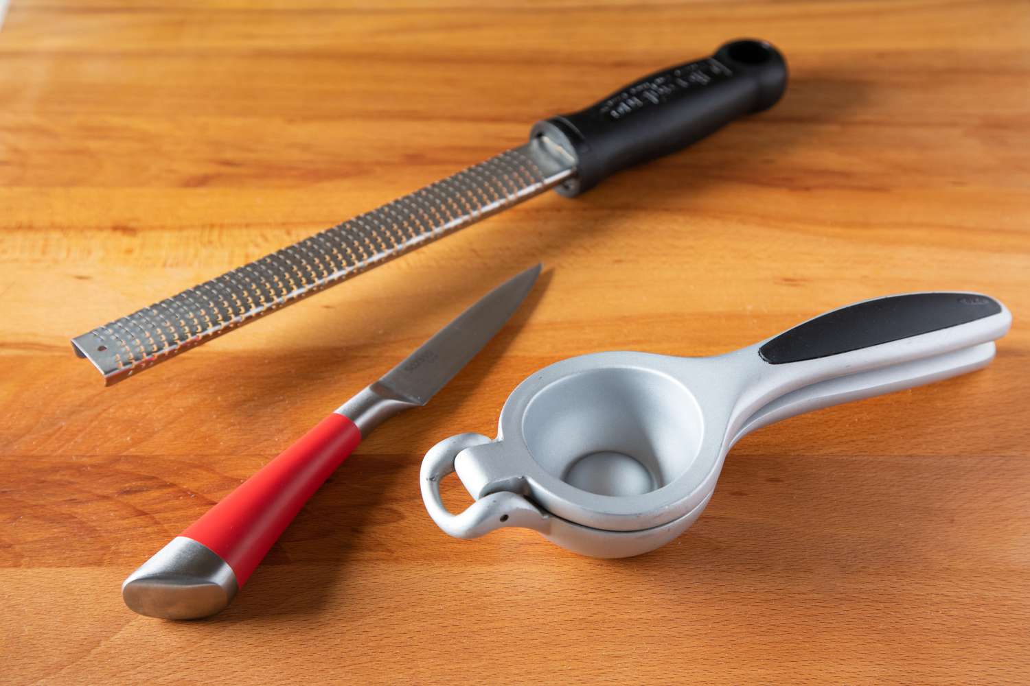 Citrus prep tools, including a zester, paring knife, and hand juicer
