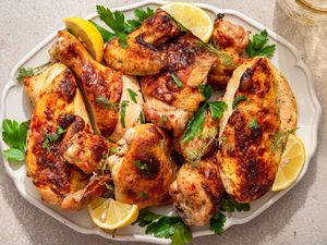 Ranch chicken topped with fresh herbs and lemon wedges on a platter