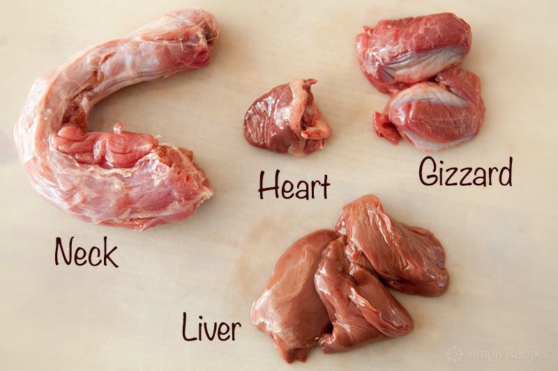 A turkey neck, heart, gizzard, and liver resting on a wooden surface
