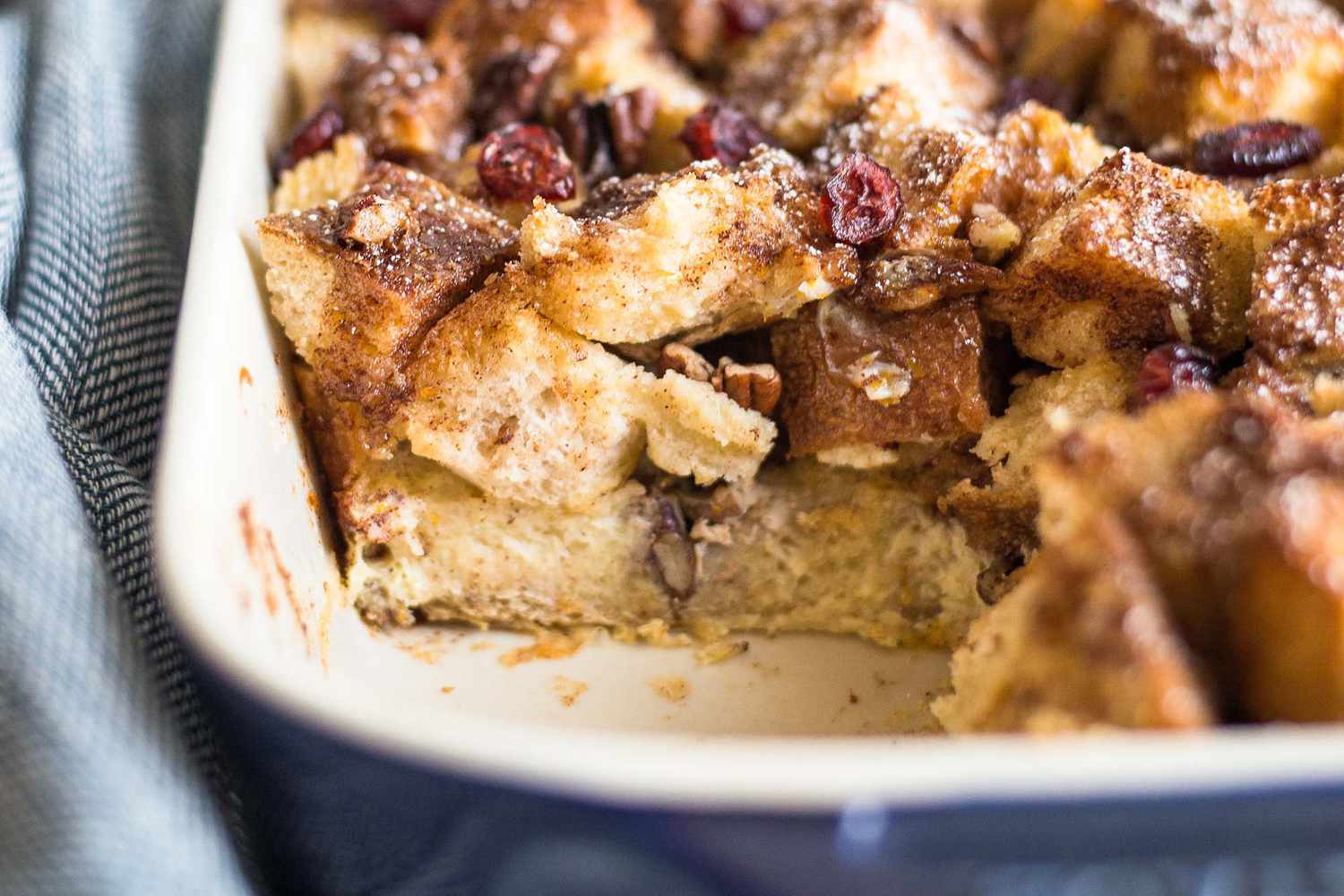 A French Toast Casserole Bake with a piece missing showing the layers