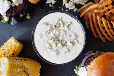 Blue Cheese Wing Dip - sauce in bowl surrounded by burgers and sides