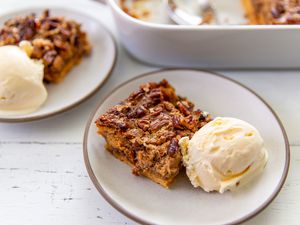 square slice of Pumpkin Dump Cake with a scoop of ice cream on a plate