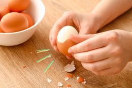 Someone peeling hard boiled eggs