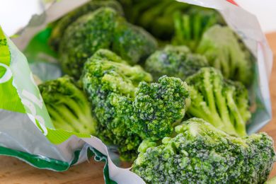 Frozen broccoli spilling out of a bag