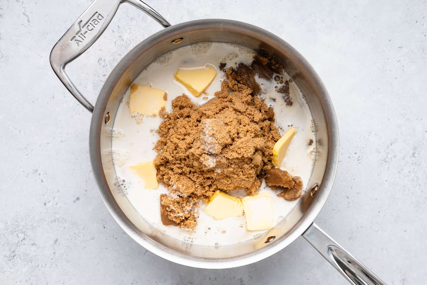 Brown sugar, whole milk, butter, and salt added to a pot for penuche recipe