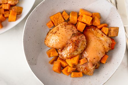 Overhead view of a bowl of roast chicken and sweet potatoes