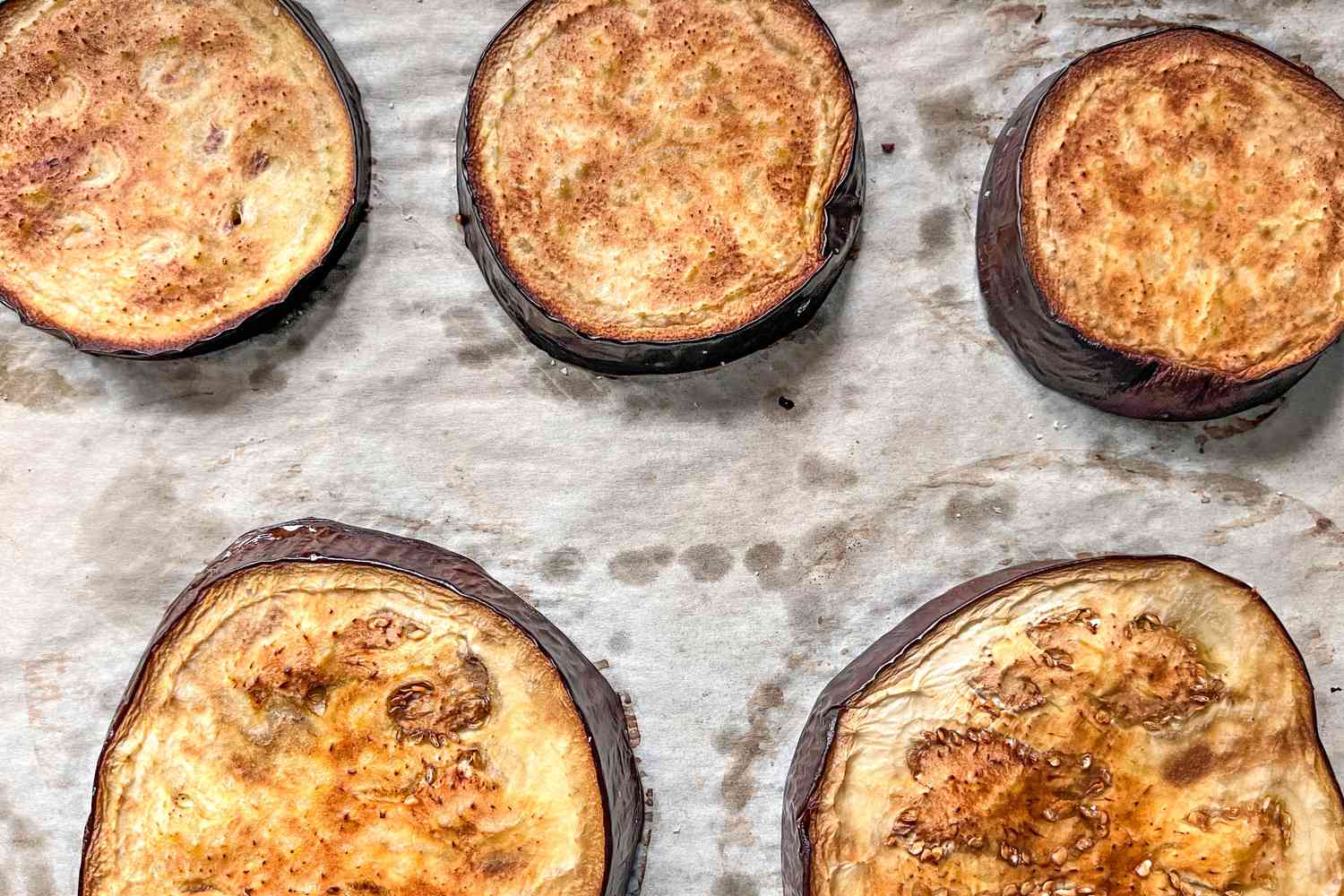 Roasted Eggplant Slices on a Parchment Paper Lined Baking Sheet