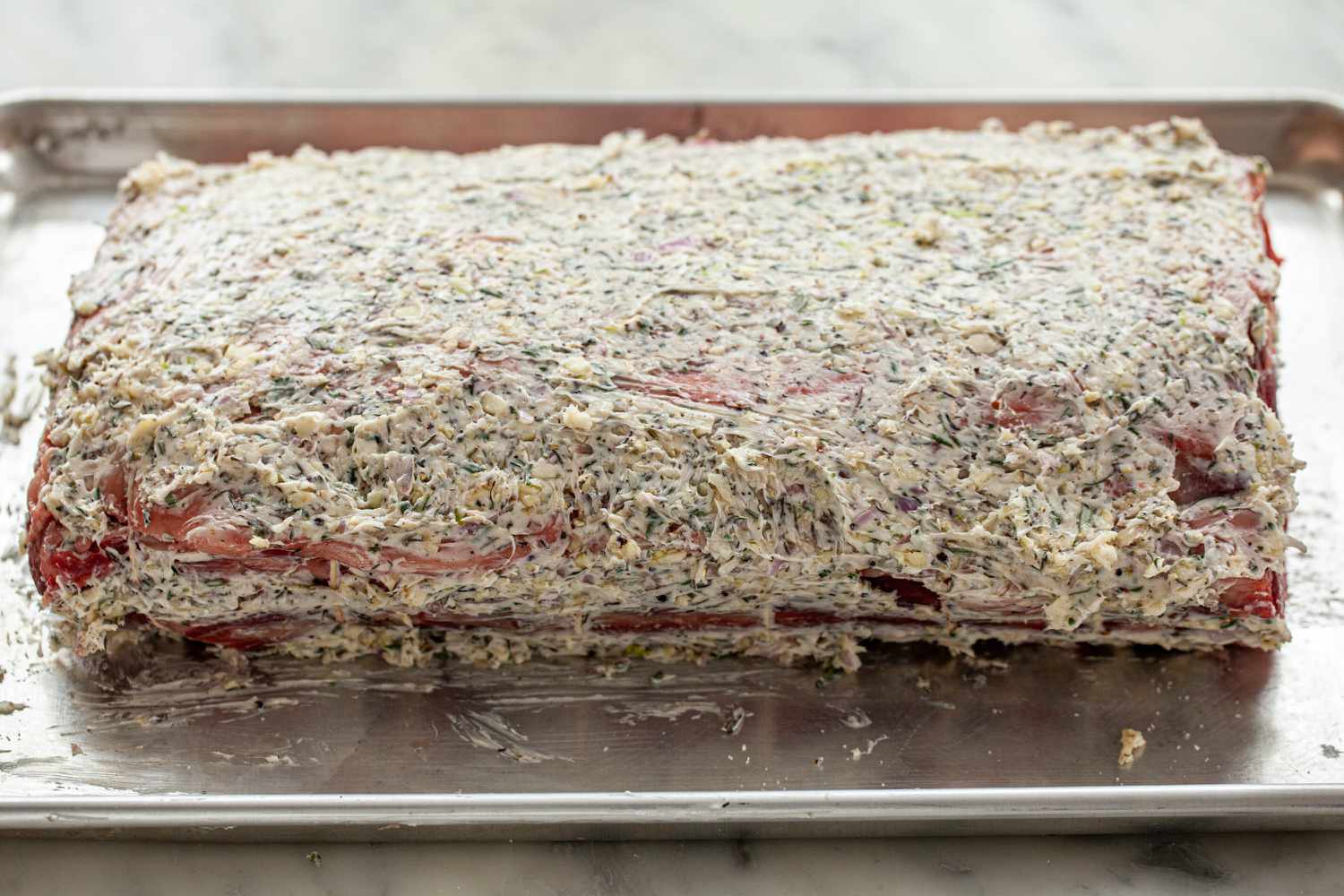 A prime rib rubbed with herb butter to make Garlic, Rosemary and Thyme Prime Rib.