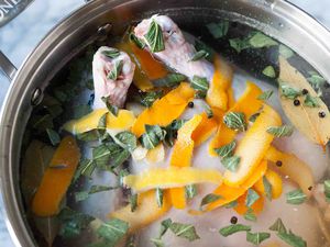 A turkey in a brine with herbs and orange peels