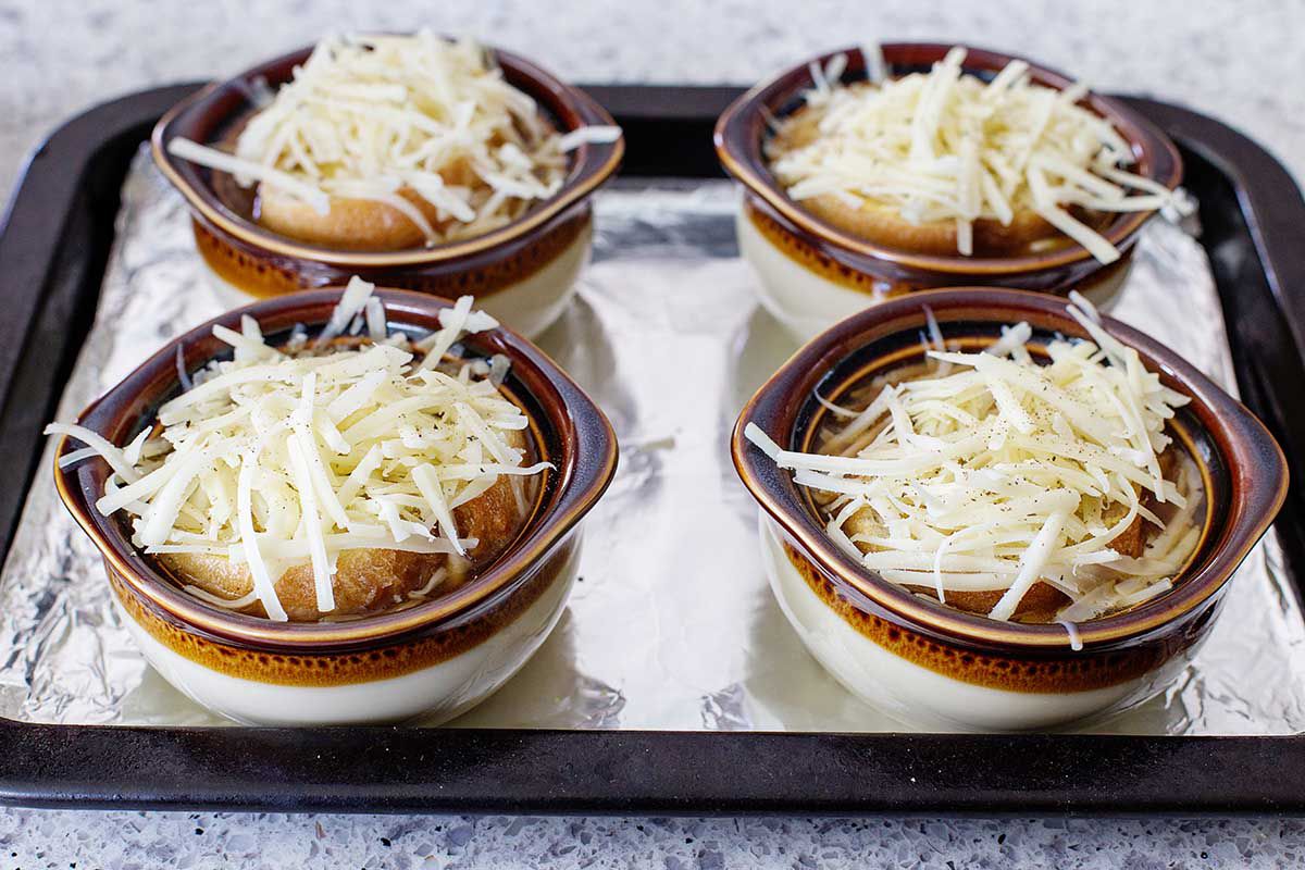 French Onion Soup made in the instant pot in brown stoneware bowls topped with cheese.