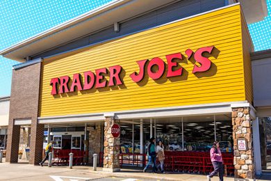 Exterior view of a Trader Joe's store entrance with patrons entering and exiting