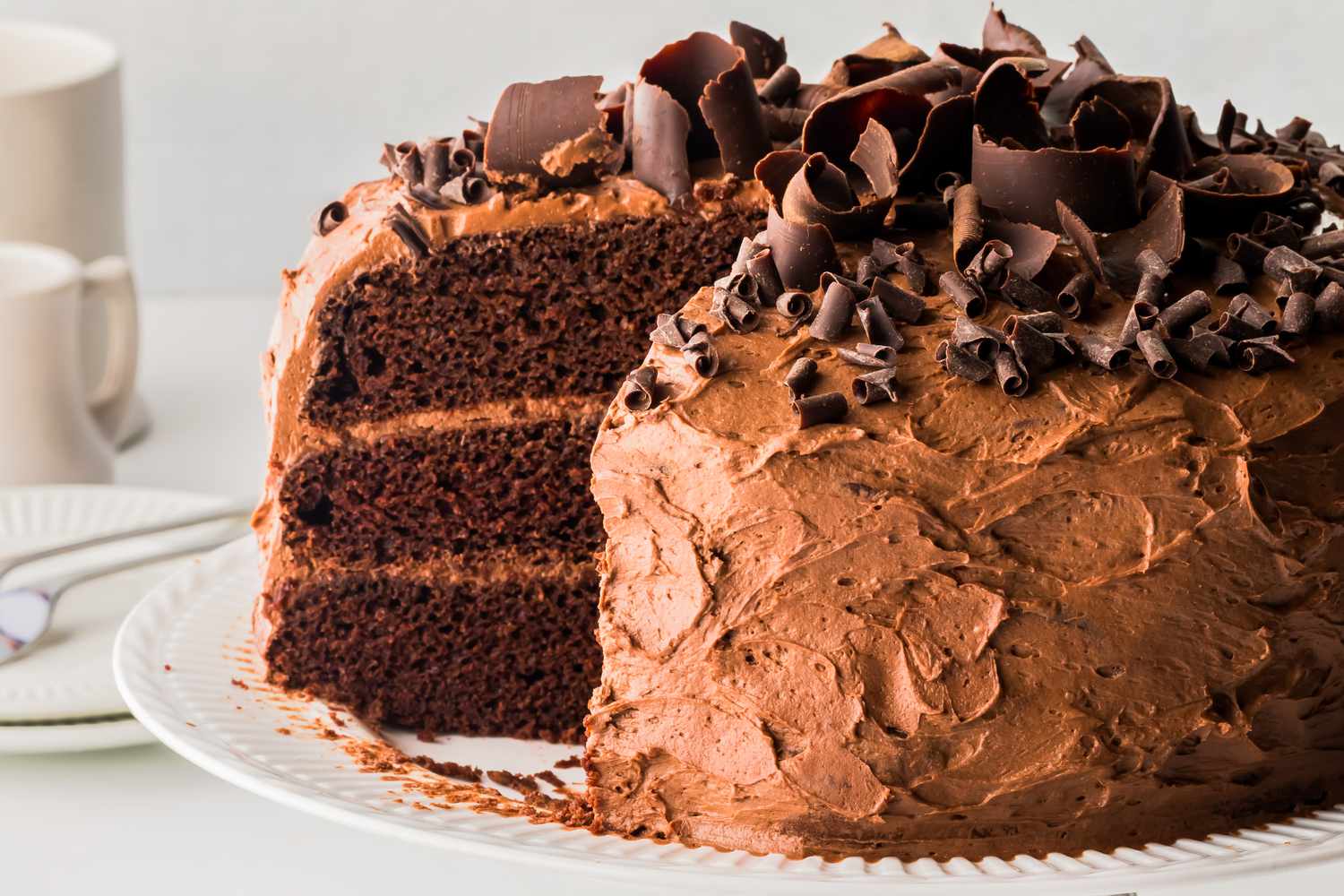 Triple layered chocolate cake topped with a slice missing