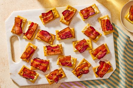 Overhead view of a serving board of millionaire crackers appetizer on top of a striped cloth napkin